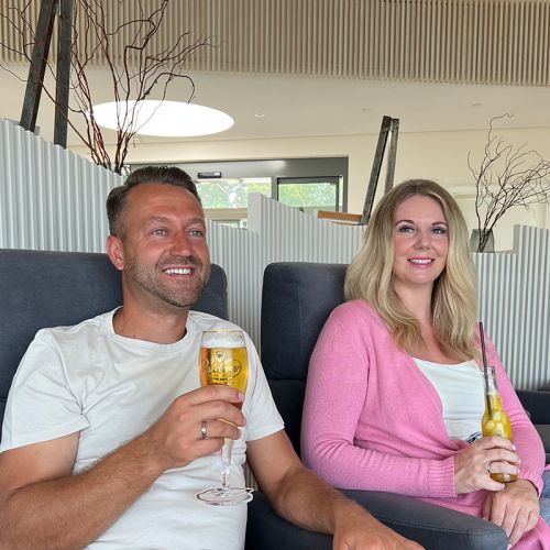 Restaurant Hotel Haus am Meer, Lobby, Pärchen sitzt in Sesseln, jeder hat ein Getränk in der Hand, beide schauen lächelnd in den räum