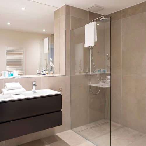 Modern gefliestes Badezimmer in braun/grauen Fliesen mit barrierefreier Dusche