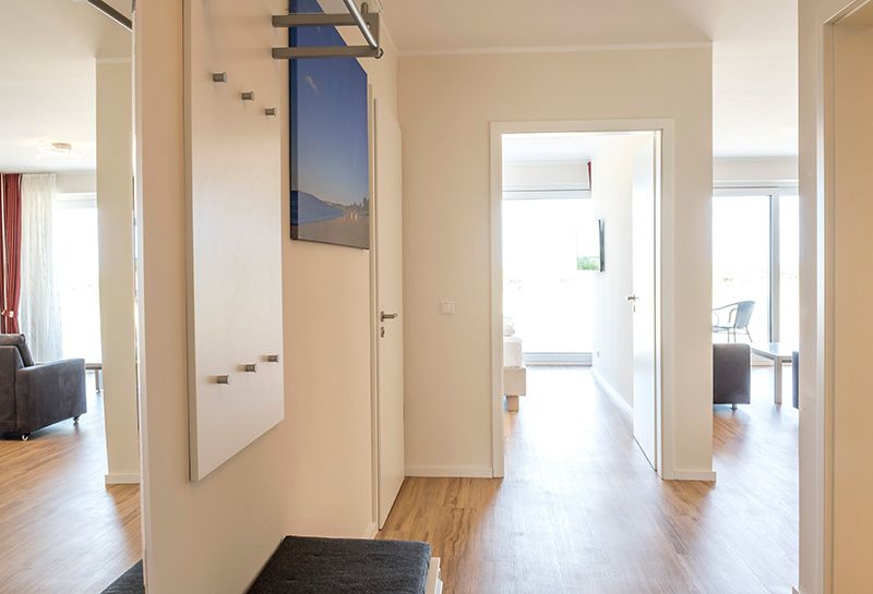Flur und Garderobe Classic Appartements in modernen beige/weiß Tönen. Blick führt durch die Fensterfront auf die Ostsee.