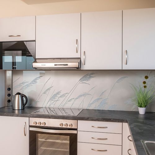 Exclusive Appartement Küche in modernen weiß und grau Tönen. Herd, Kochplatte und Mikrowelle sind vorhanden.