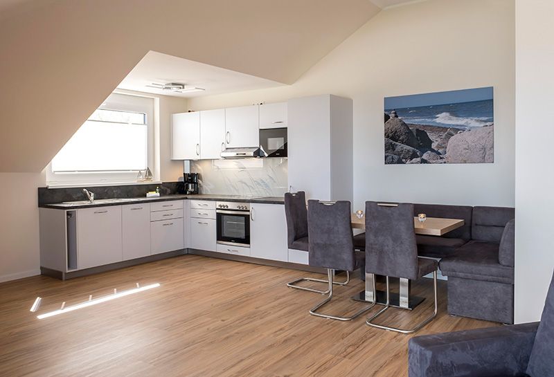 Penthouse Küche in modernen weiß und grau Tönen. Herd, Kochplatte und Mikrowelle sind vorhanden.