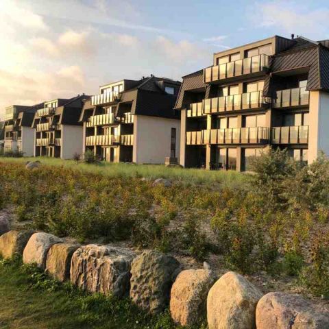 Hotel Haus am Meer, schräge Ansicht der Appartementgebäude zur Meerseite, Abendstimmung, Sonnenuntergang leuchtet in den Glaselementen der Gebäude