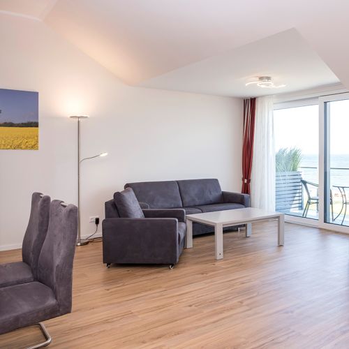 Penthouse Wohnzimmer mit riesiger Fensterfront und Ausblick auf die Ostsee