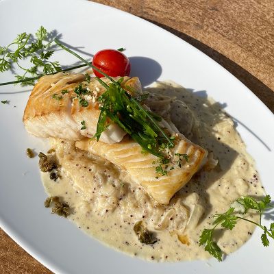 weißer ovaler Teller mit Fischgericht