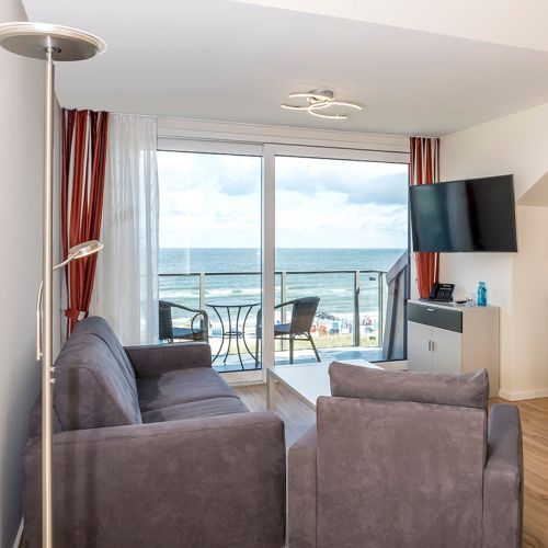 Penthouse Wohnzimmer mit riesiger Fensterfront und Ausblick auf die Ostsee
