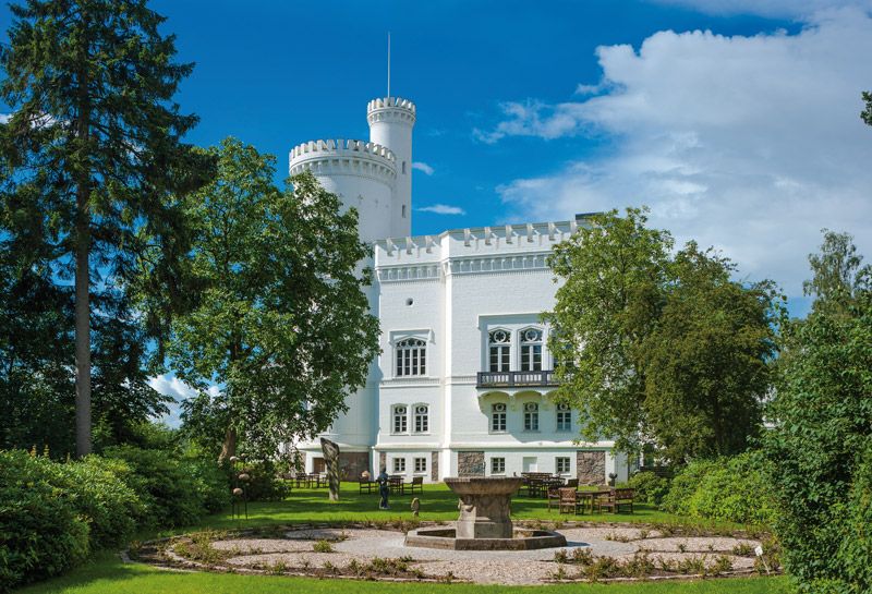 Aktivitäten Hohwachter Bucht, Schlösser und Herrenhäuser, Ansicht der Blomenburg, drumherum grüne Bäume, im Vordergrund Springbrunnen